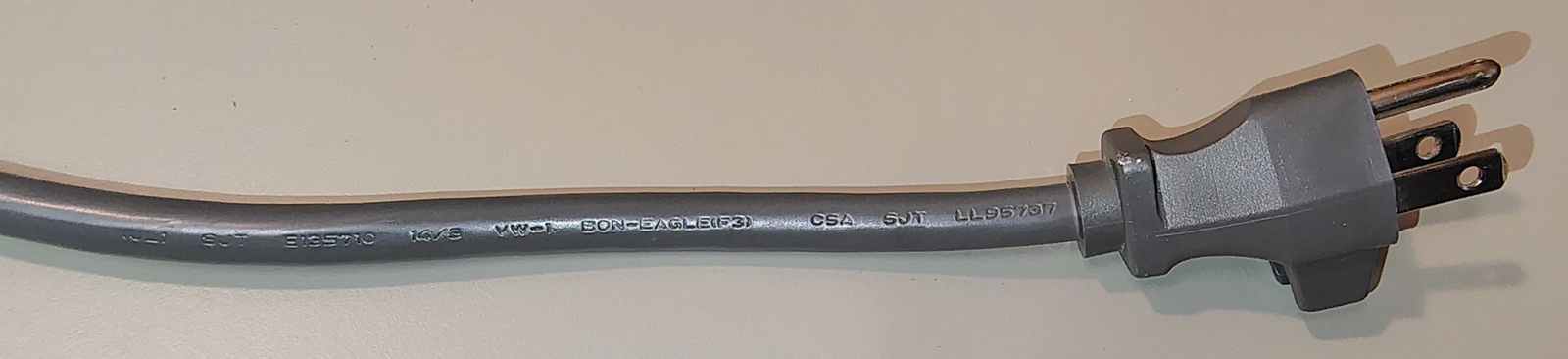 Power cord and attachment plug showing the integrated cord-retention clip and molded plug assembly.