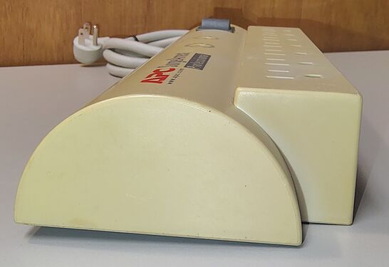 Rounded outlet-end profile showing the characteristic APC SurgeArrest Professional enclosure design and substantial enclosure yellowing.