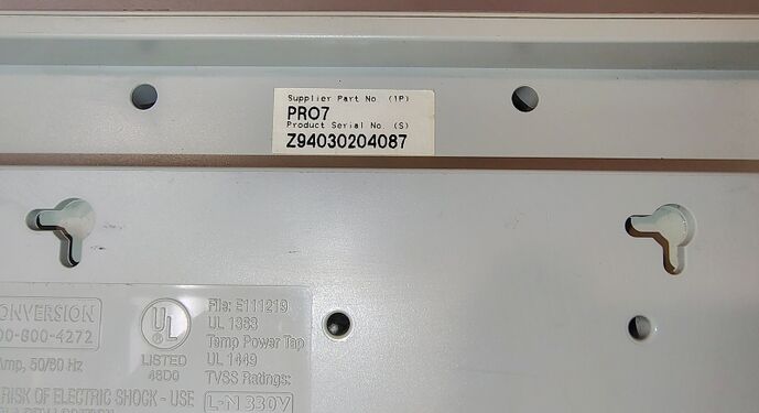 Serial-number label, wall-mount slots, and underside markings.