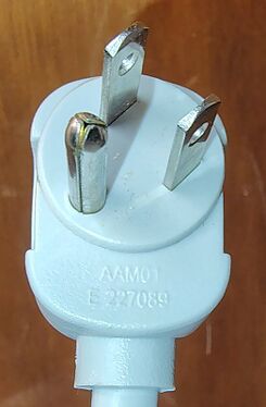 Right-angle attachment plug showing molded approval markings and certification information.