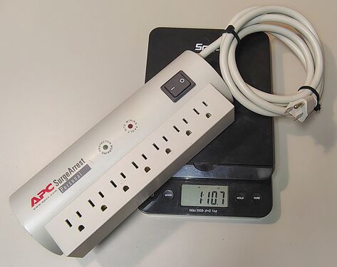 APC SurgeArrest Personal PER7T on a digital scale showing a weight of approximately 1 lb 10.7 oz (757 g).