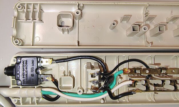 Cord-entry end showing internal wiring and circuit breaker.