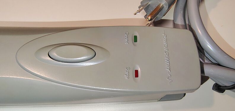 Control section showing the push-button power switch, Ground indicator, and Surge indicator.