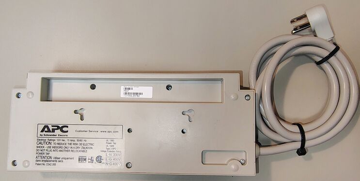 Bottom view showing mounting features, regulatory labels, and serial-number label.