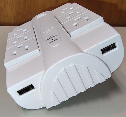 Top oblique view showing the rotating outlet banks, dual USB charging ports, and status indicators.