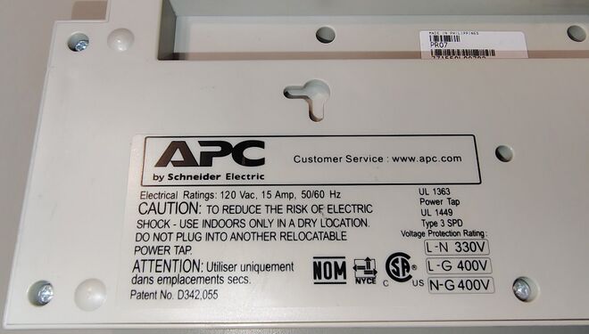 Regulatory-information label showing electrical ratings, certifications, and voltage protection ratings.