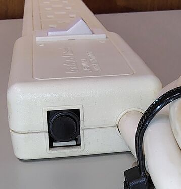 Cord-entry end showing the resettable circuit breaker and power-cord strain relief.