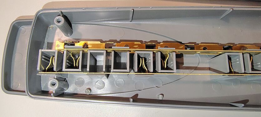 Transformer-spaced outlet section showing stamped-brass conductors and receptacle contacts.