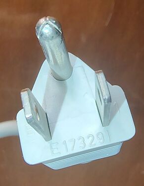 Close-up of the attachment plug showing molded identification markings and grounding-pin wear.