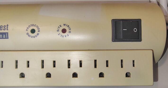 Protection Working indicator, Site Wiring Fault indicator, rocker switch, and preserved outline of a previously attached label demonstrating differential enclosure discoloration.
