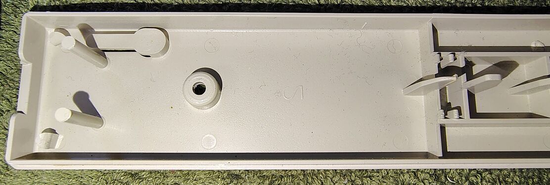 Upper-enclosure cord-entry section showing molded structural features and cavity markings.