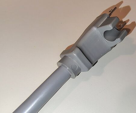 Close-up view of the integrated cord-retention clip incorporated into the attachment plug.
