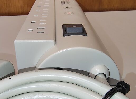 Cord-entry end showing strain relief, rocker switch, enclosure profile, and attached power cord.