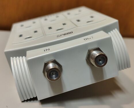 Integrated coaxial surge-protection connectors labeled IN and OUT.