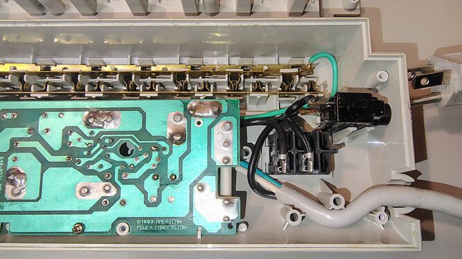 Cord-entry end showing the ©1993 suppression board, switch assembly, wiring, and outlet-contact strips.