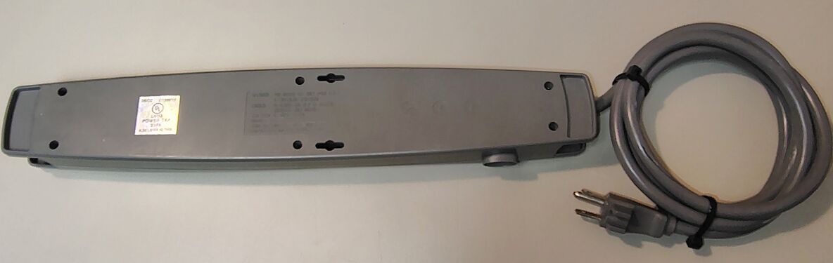 Underside overview showing mounting provisions, labels, date wheels, and power-cord assembly.