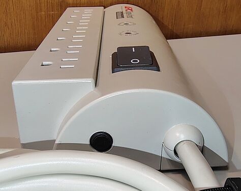 Cord-entry end showing the rocker switch, resettable circuit breaker, and power-cord strain relief.