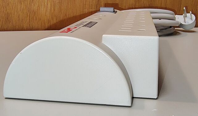 End view showing the rounded enclosure profile and outlet section.