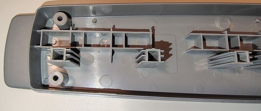 Upper enclosure detail showing molded reinforcement structures and outlet-support features.