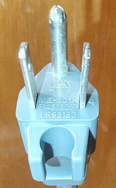 Attachment plug detail showing integrated cord-retention clip and approval markings.