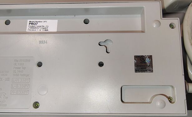 Right-side underside detail showing the UL hologram label, mounting features, serial-number recess, and enclosure markings.