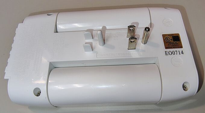 Rear view showing product markings, date wheels, UL label, and direct-plug attachment assembly.