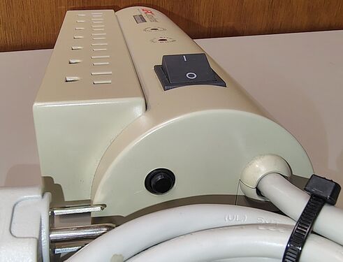 Cord-entry end showing the rocker switch, resettable circuit breaker, and attached power cord.