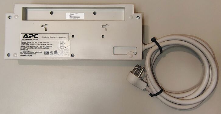Bottom view showing mounting slots, product label, and attached power cord.