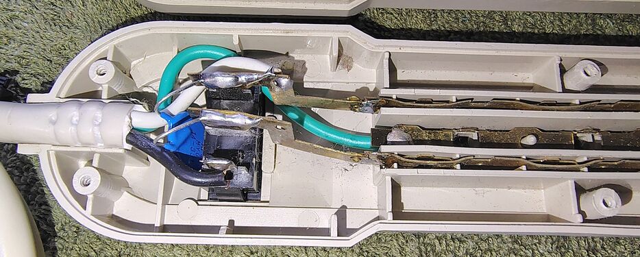 Cord-entry section showing the rocker power switch, internal wiring, and surge-suppression components.