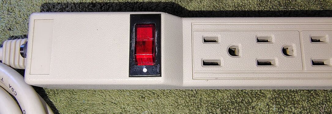 Illuminated rocker power switch and textured enclosure detail.