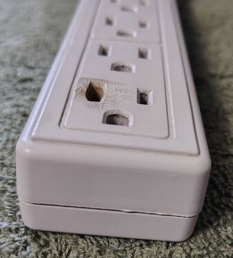 Heat-damaged outlet showing transferred plug markings.