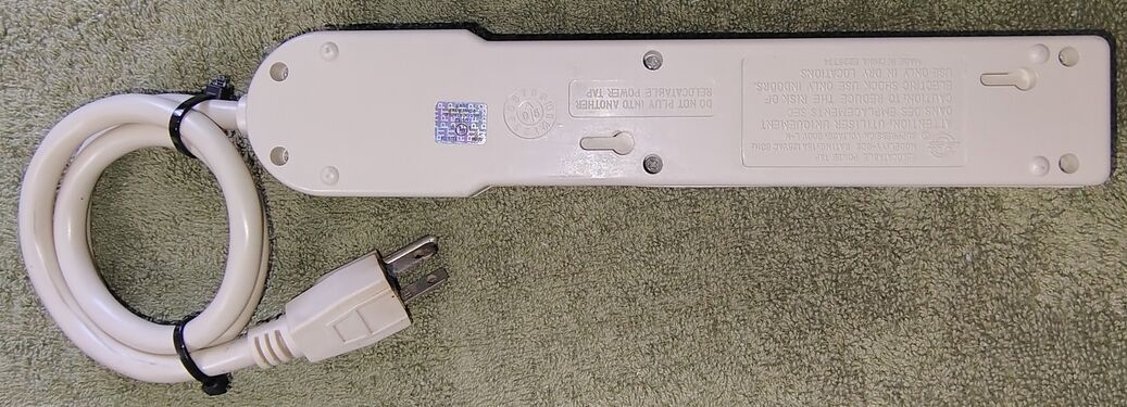 Underside view showing labels, mounting slots, and electrical information.