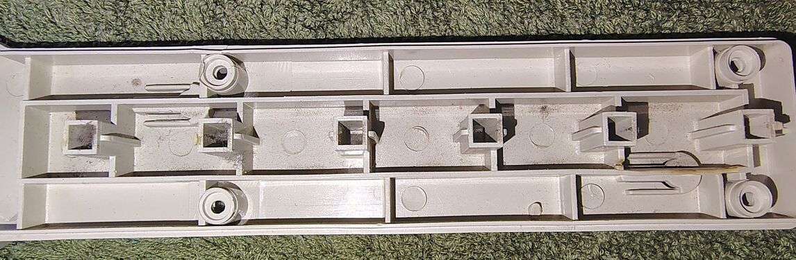 Interior view of the upper enclosure half at the heat-damaged outlet. Discoloration and deformation are visible around the affected receptacle supports.