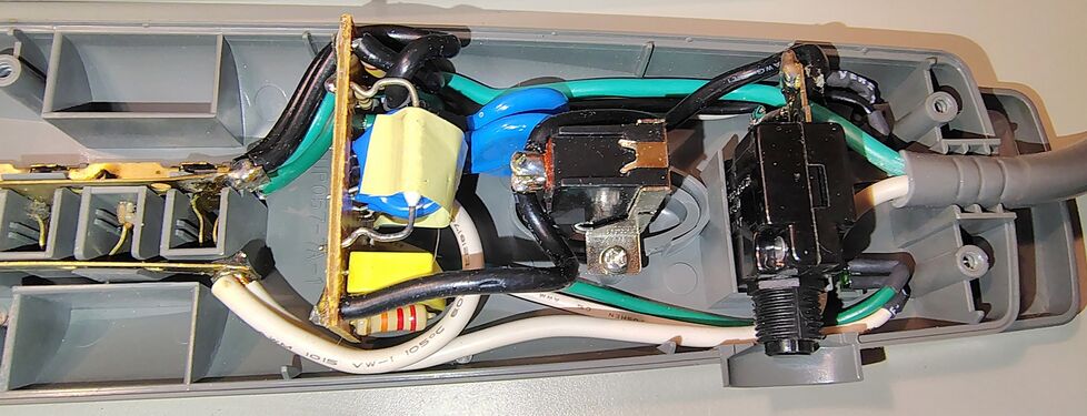 Cord-entry area showing the suppression board, circuit breaker, and push-button switch assembly.