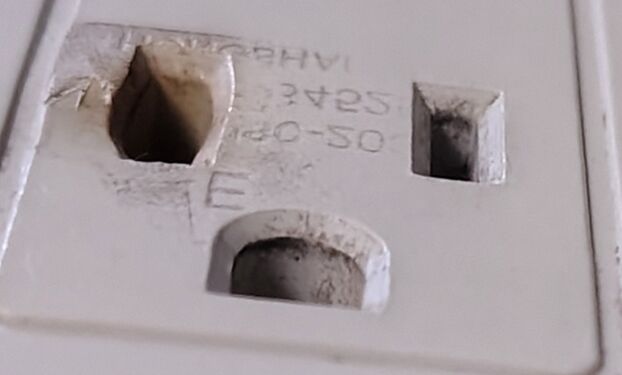 Close-up of outlet damage and transferred plug lettering.