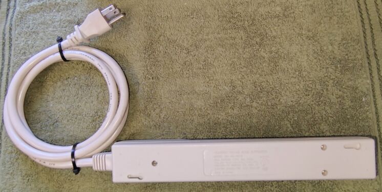 Bottom view showing mounting features, molded regulatory information, and attached power cord.