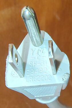 Straight-blade attachment plug showing approval markings and manufacturer identifiers.