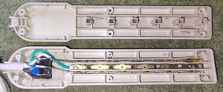 YY-6CS opened following removal of the enclosure screws. Internal construction consists of stamped brass outlet contacts, a rocker power switch, and direct-wired surge-protection circuitry.