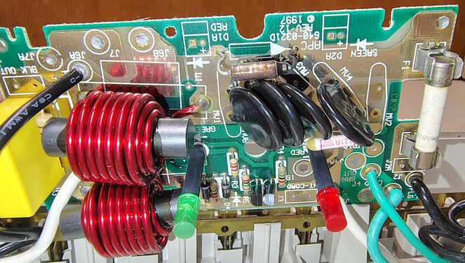 Suppression circuitry showing dual toroidal filtering inductors, MOV surge suppressors, fuse protection, and status-indicator components.