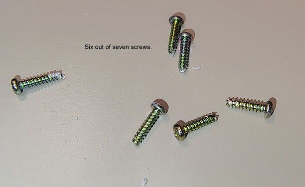 Six of the seven enclosure screws removed during disassembly.