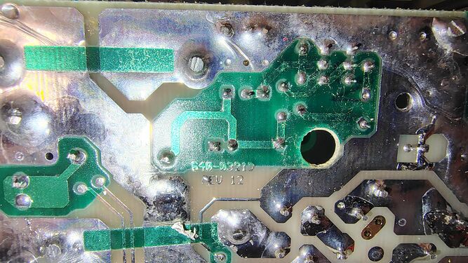 Close-up of the suppression board underside showing revision markings, traces, and solder connections.