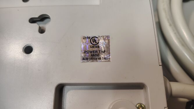 Close-up of the UL hologram label marked 07/99 and identifying the device as a listed power tap and TVSS.
