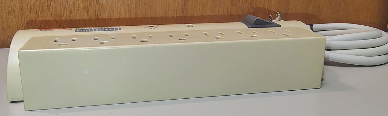 Flat-side profile showing the seven-outlet receptacle section, enclosure condition, and overall mechanical design of the documented APC PRO7 specimen.