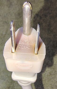 Attachment plug showing certification markings and evidence of heat-related discoloration.