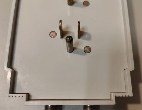 Lower rear detail showing one plug assembly, riveted enclosure construction, and molded markings.