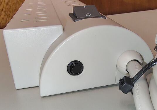 Cord-entry end showing the resettable circuit breaker and power-cord strain relief.