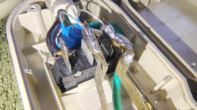 Close-up of the rocker switch terminals and surge-suppression components connected across the power conductors.